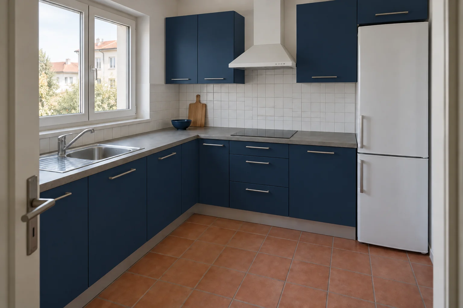 Deep blue cabinet fronts create a strong contrast with the white tile and warm floor.