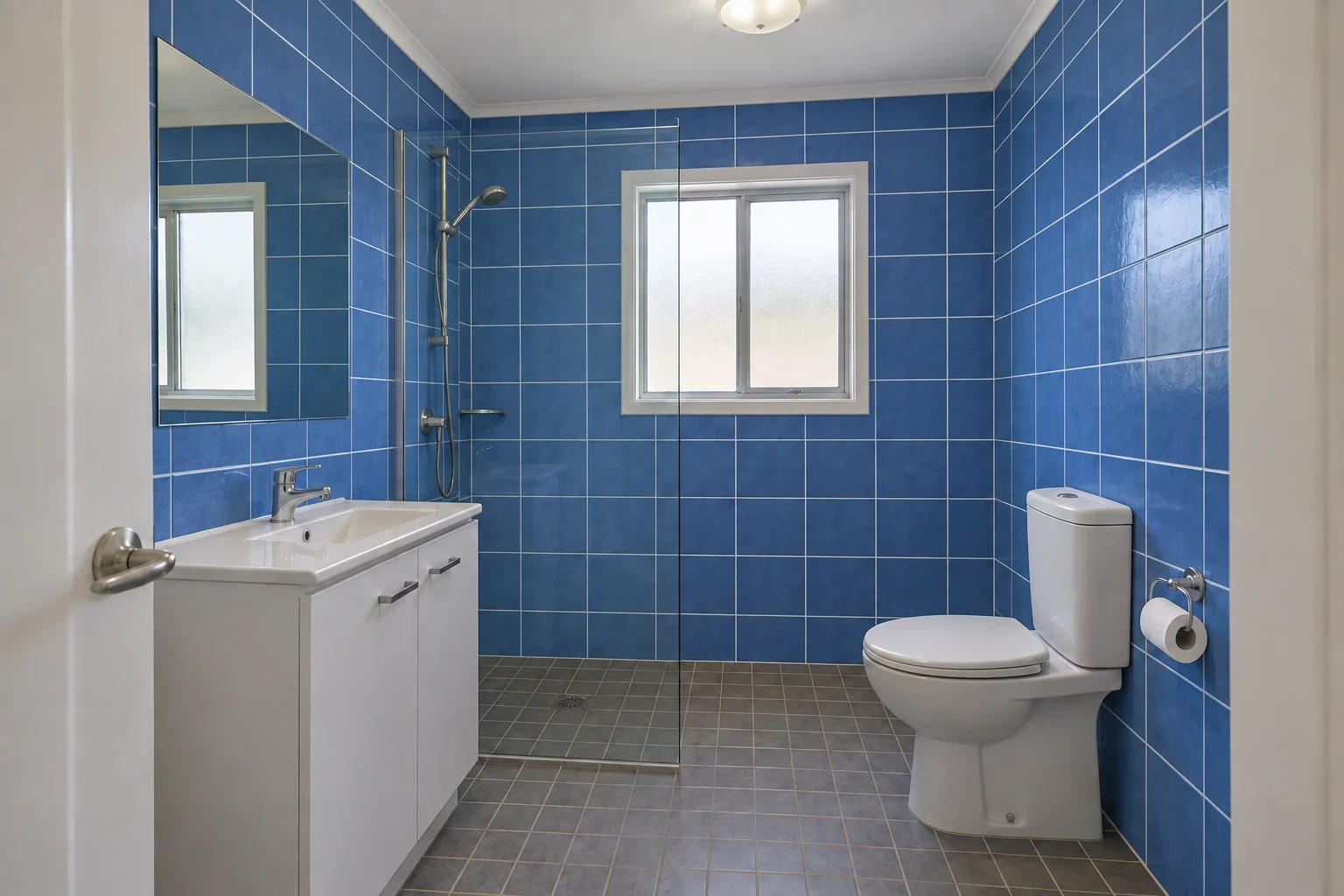 Blue bathroom wall tile with a stronger white grout grid.